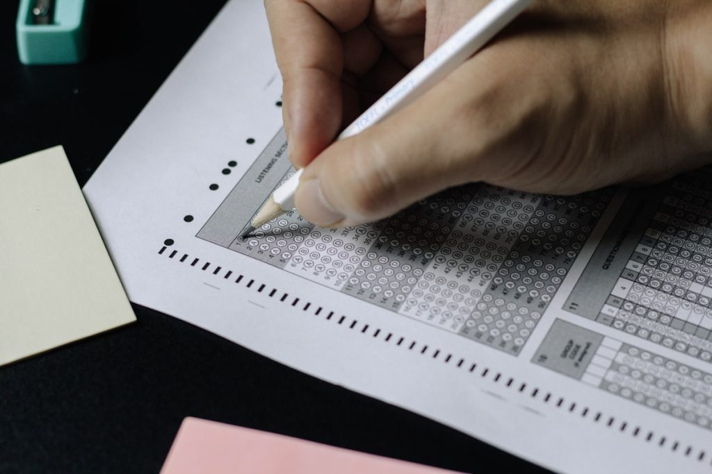 Dłonie wypełniające test — quizy i certyfikaty w kursach online