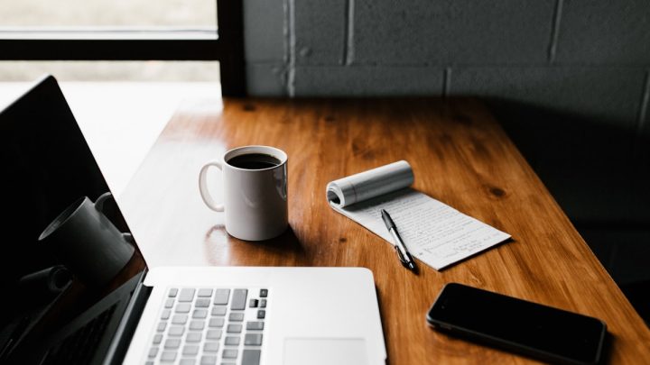 Laptop z kawą na biurku — nauka online i darmowe platformy do kursów